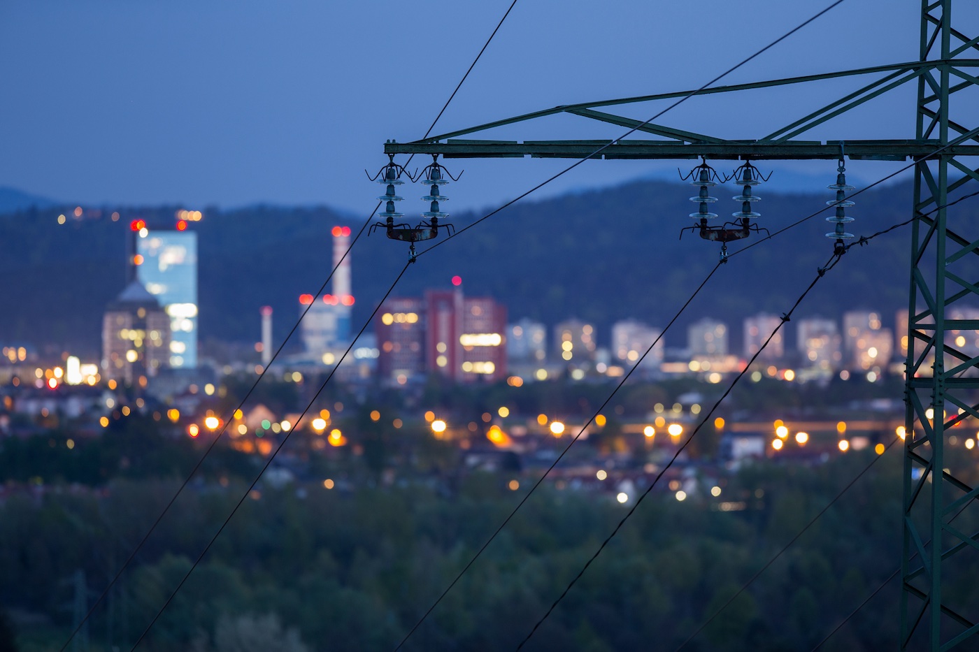 Power lines run down into a city that uses the utility SaaS provider